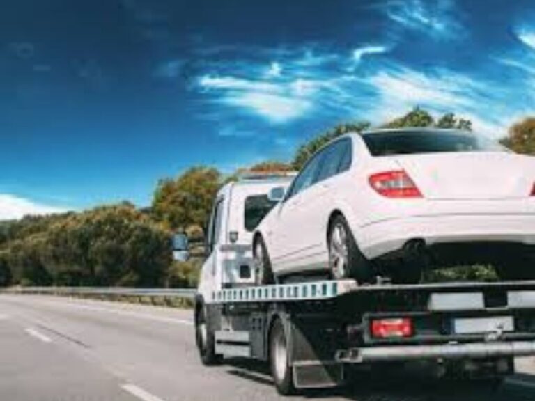 Flatbed tow truck loading sedan on Caroline Springs Boulevard outside Stockland
