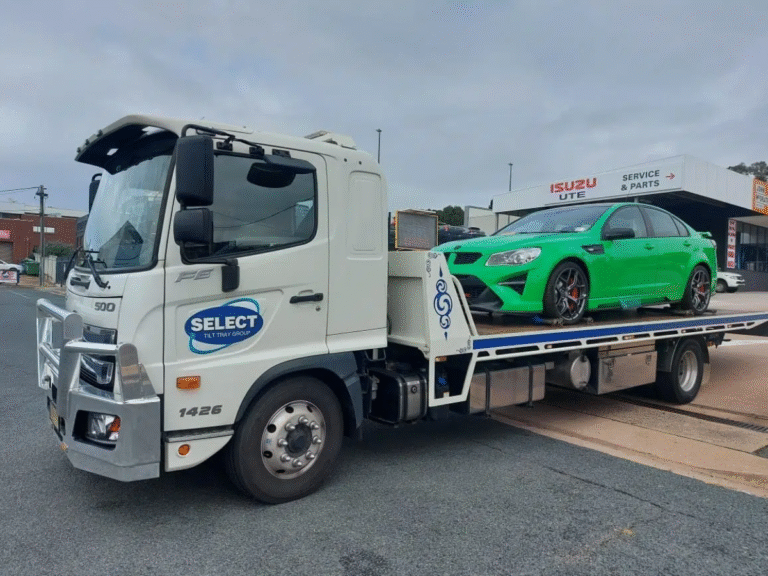 Tilt-tray tow truck near me on Beaconsfield Parade St Kilda with beach in background