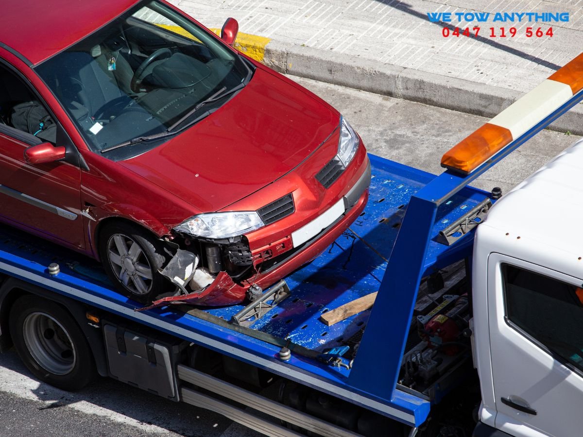 We Tow Anything flatbed tow truck loading an accident-damaged vehicle in Euroa VIC 3666 for safe recovery