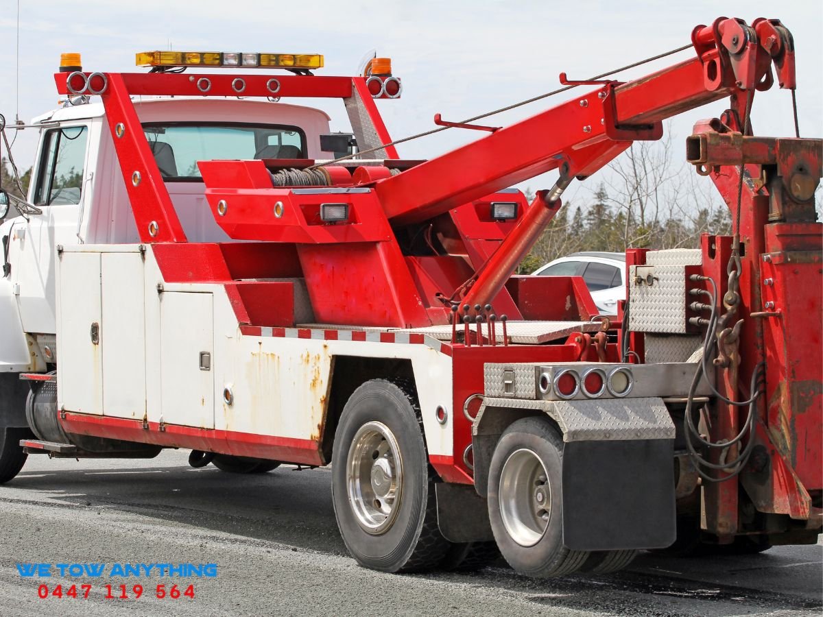 We Tow Anything heavy-duty tow truck recovering a bogged tractor on a Longwood Plains farm road in Strathbogie Shire VIC 3665